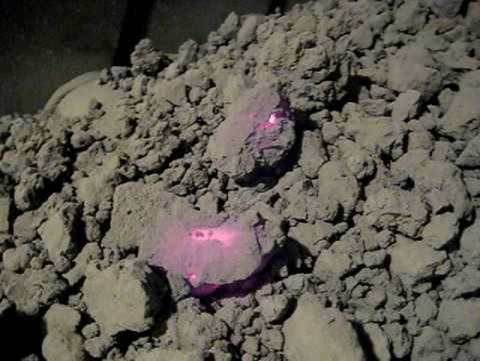 Aggregate material cooling on a conveyor belt after being discharged from the Rotary Kiln; some of the aggregate material is retaining enough heat to glow red