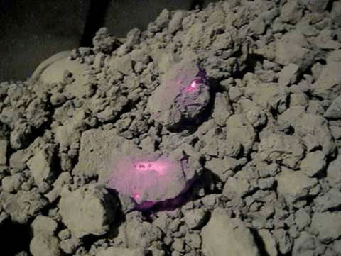 Rotary_Kiln_Conveyor_Belt_Protection Aggregate material cooling on a conveyor belt after being discharged from the Rotary Kiln; some of the aggregate material is retaining enough heat to glow red